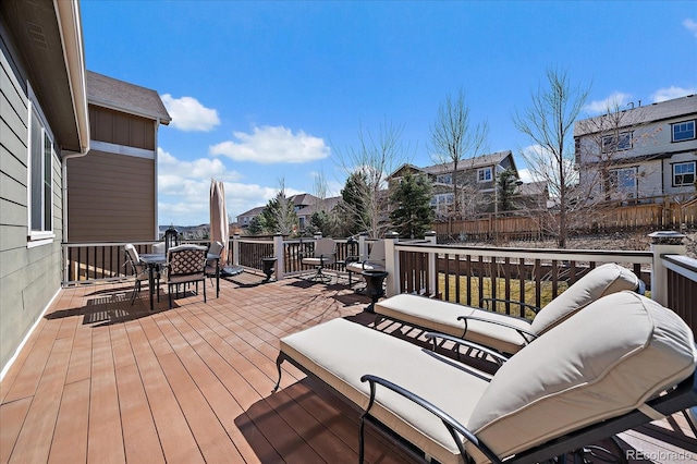 wooden terrace with outdoor dining space, a residential view, and outdoor lounge area