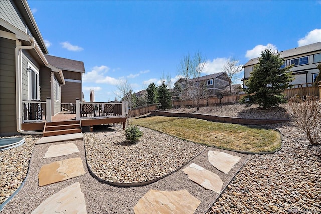 view of yard with a deck, a fenced backyard, and a residential view