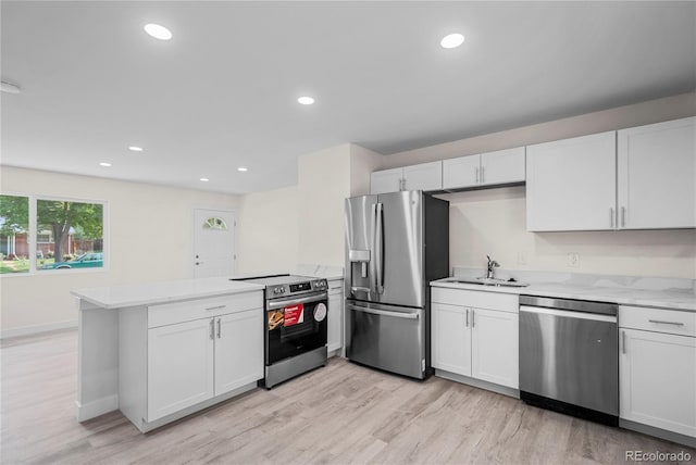 kitchen featuring kitchen peninsula, sink, light wood-type flooring, white cabinetry, and appliances with stainless steel finishes