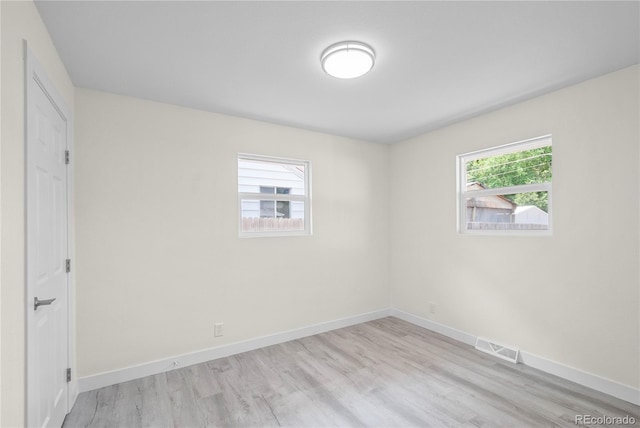 spare room with a wealth of natural light and light wood-type flooring