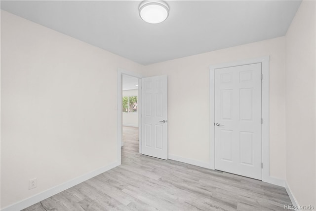 unfurnished bedroom with a closet and light wood-type flooring