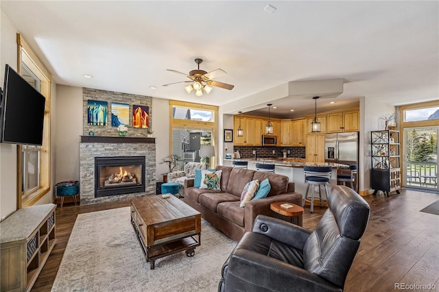 133 Creek Ln, Silverthorne, CO 80498 - living area featuring healthy amount of natural light, dark wood-style flooring, a fireplace, a ceiling fan, and recessed lighting