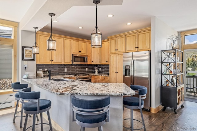 133 Creek Ln, Silverthorne, CO 80498 - kitchen with stainless steel appliances, dark wood-style floors, decorative backsplash, a breakfast bar area, and recessed lighting