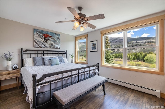 133 Creek Ln, Silverthorne, CO 80498 - bedroom with baseboard heating, multiple windows, wood finished floors, and a ceiling fan