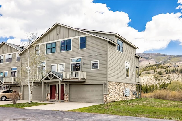 133 Creek Ln, Silverthorne, CO 80498 - view of front of house featuring board and batten siding, stone siding, an attached garage, and driveway