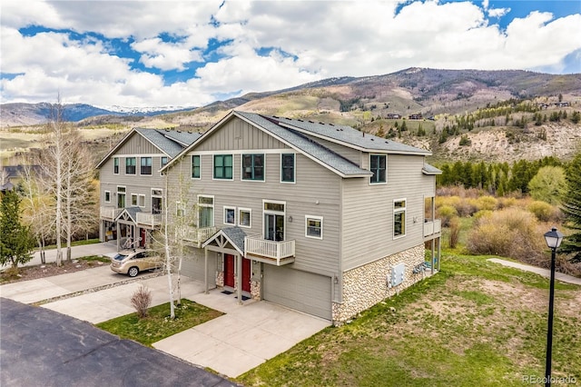 133 Creek Ln, Silverthorne, CO 80498 - townhome / multi-family property featuring a mountain view, concrete driveway, a garage, board and batten siding, and stone siding