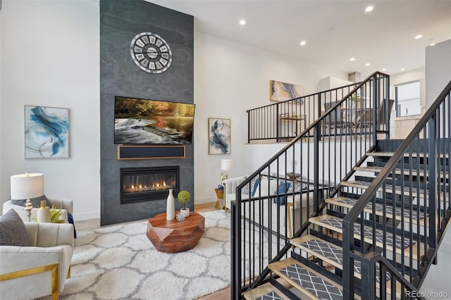 staircase featuring a large fireplace and wood-type flooring