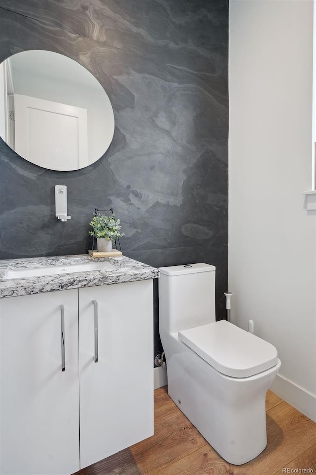 bathroom featuring hardwood / wood-style flooring, toilet, and vanity