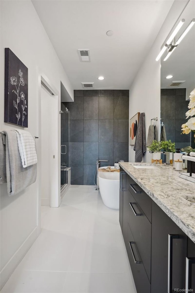 bathroom featuring oversized vanity, tile walls, and tile floors