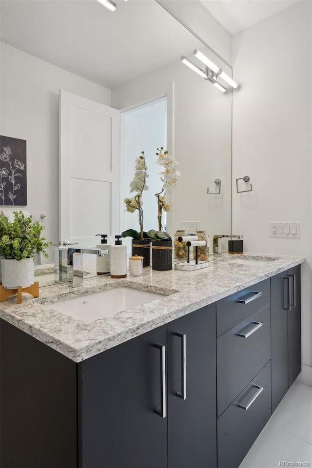 bathroom with tile floors, vanity with extensive cabinet space, and double sink