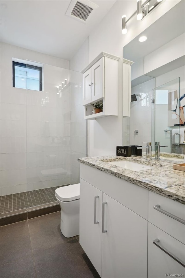 bathroom with vanity with extensive cabinet space, walk in shower, tile flooring, and toilet