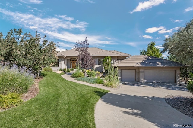 prairie-style home featuring a garage, driveway, a front lawn, and stucco siding