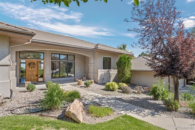 exterior space with a tiled roof and stucco siding