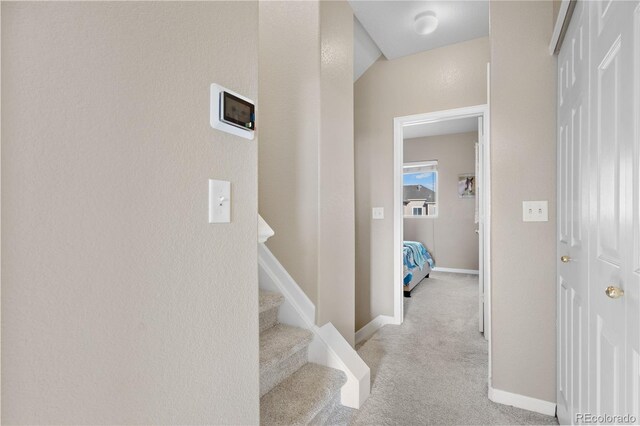 hall featuring light colored carpet and vaulted ceiling