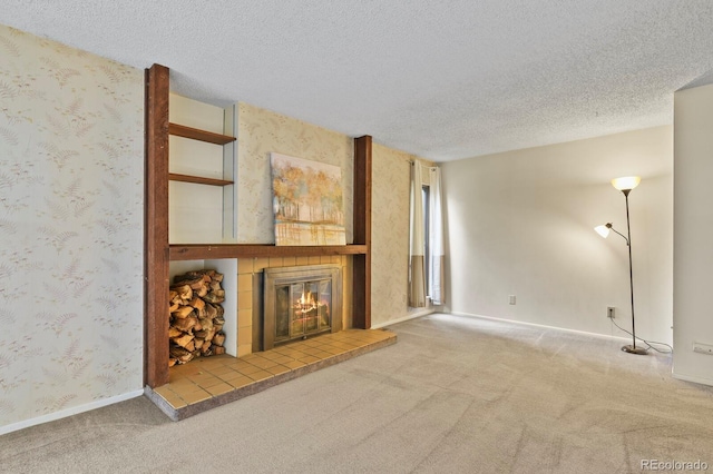 unfurnished living room with a fireplace, carpet, and a textured ceiling