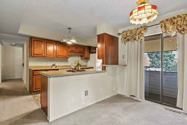 kitchen featuring light carpet, decorative light fixtures, a notable chandelier, white fridge, and kitchen peninsula