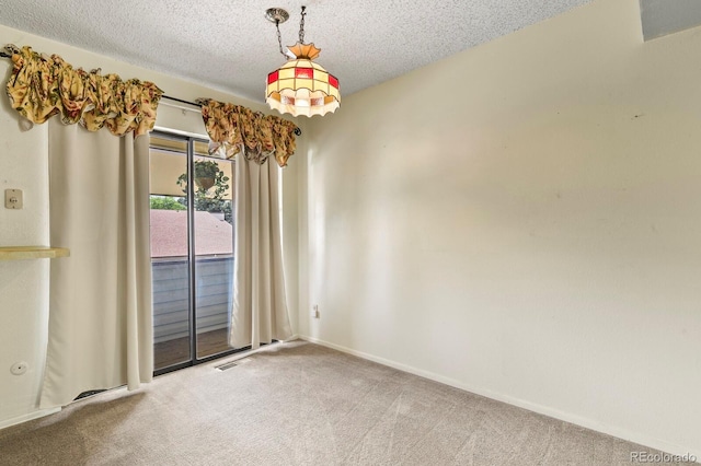 empty room with carpet flooring and a textured ceiling