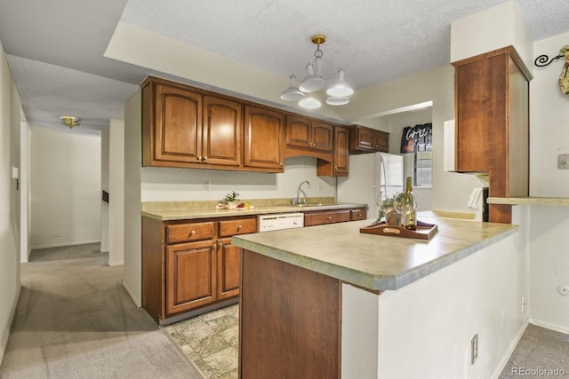 kitchen featuring light carpet, a textured ceiling, white appliances, sink, and decorative light fixtures