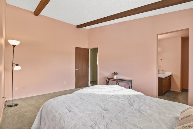 bedroom featuring ensuite bathroom, dark carpet, and beam ceiling