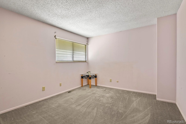 carpeted empty room featuring a textured ceiling