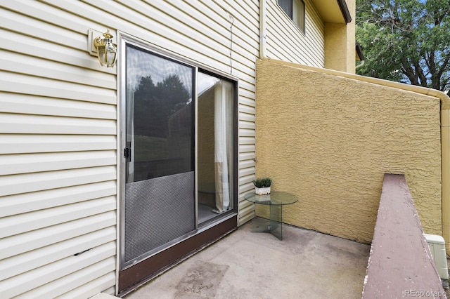 view of exterior entry with a balcony