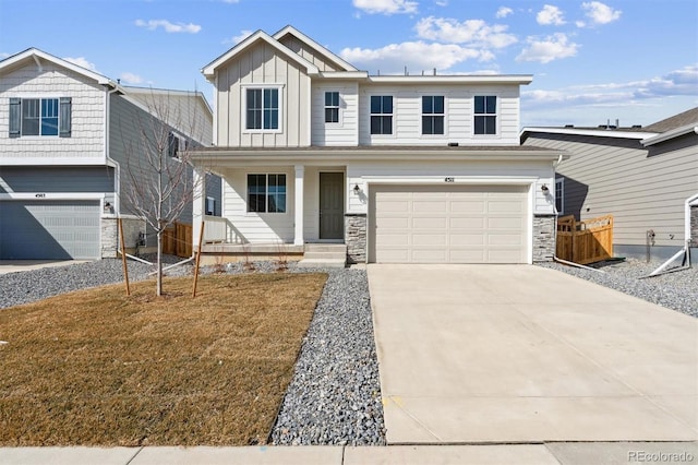 view of front of home with a porch, an attached garage, concrete driveway, stone siding, and board and batten siding