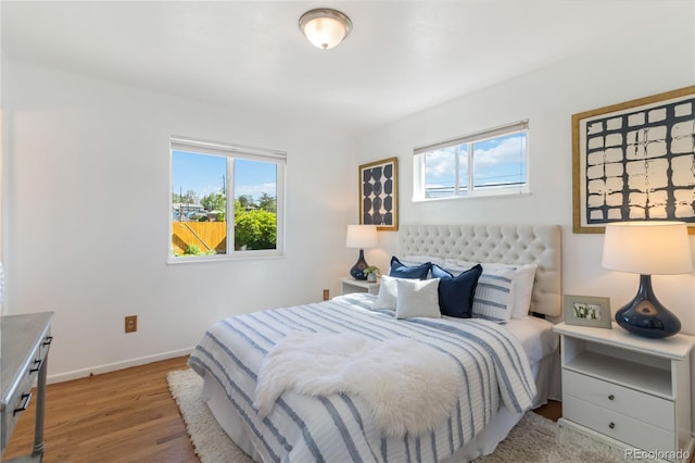 5593 E Center Ave, Denver, CO 80246 - bedroom featuring multiple windows, wood finished floors, and baseboards