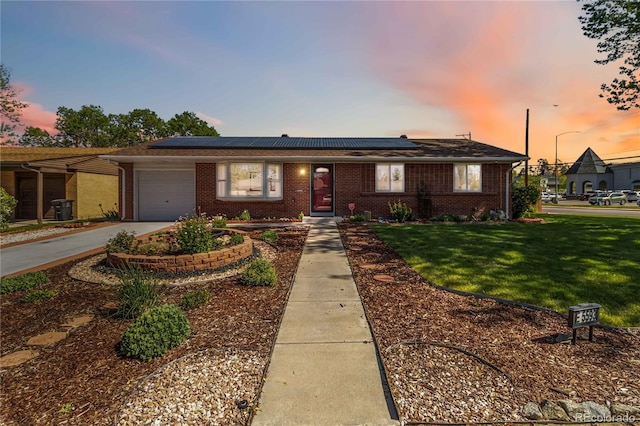 5593 E Center Ave, Denver, CO 80246 - view of front of property with a garage, brick siding, a lawn, and solar panels