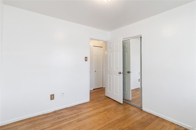 5593 E Center Ave, Denver, CO 80246 - unfurnished bedroom featuring baseboards, light wood-style floors, and a closet