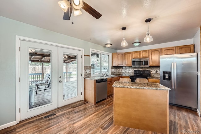 kitchen with a sink, french doors, stainless steel appliances, a kitchen island, and visible vents
