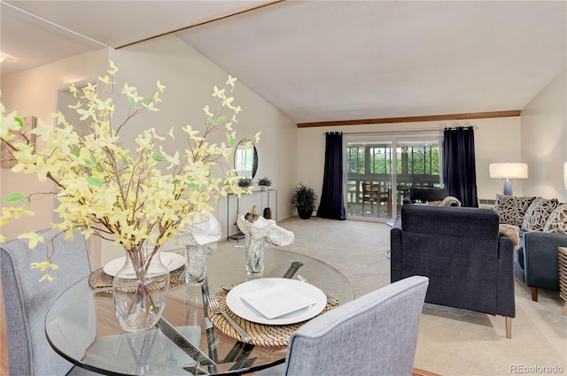 dining room featuring light colored carpet and lofted ceiling