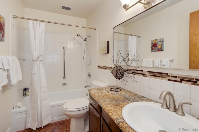 full bathroom with toilet, wood finished floors, shower / bath combination with curtain, tasteful backsplash, and vanity