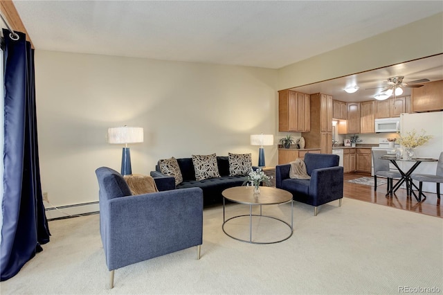 living area featuring light colored carpet, a baseboard heating unit, and ceiling fan