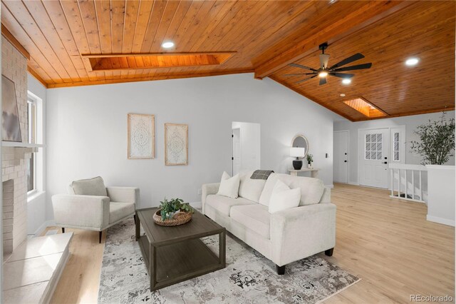 living room with ceiling fan, light wood-type flooring, wood ceiling, and plenty of natural light