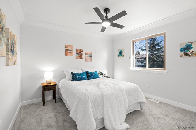 carpeted bedroom featuring ceiling fan and crown molding