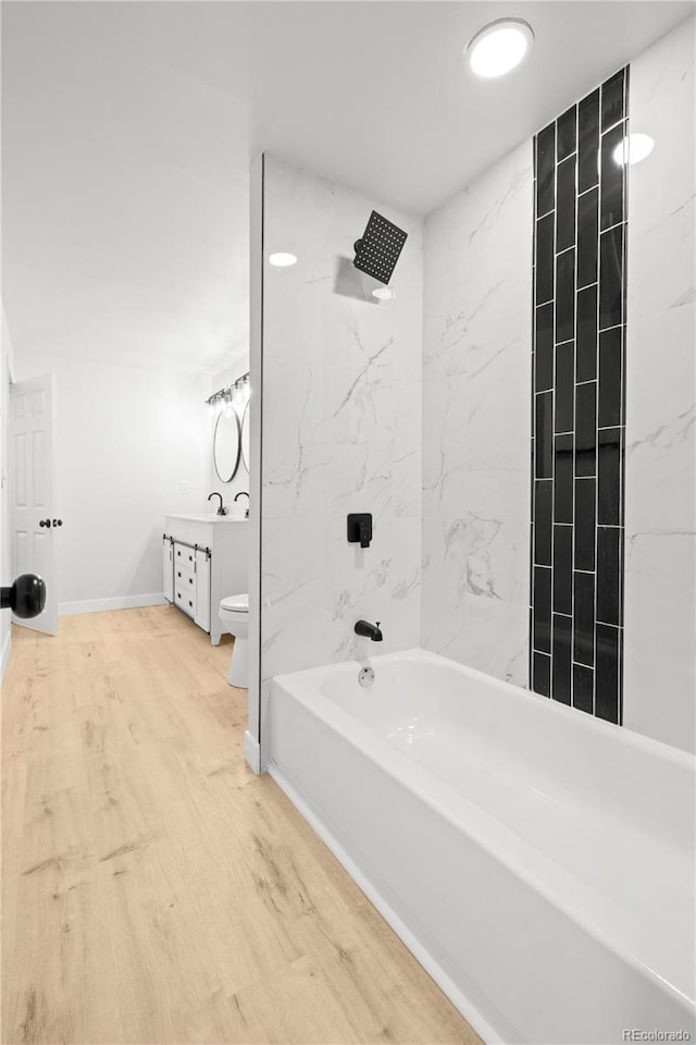 full bathroom featuring vanity, hardwood / wood-style flooring, toilet, and tiled shower / bath