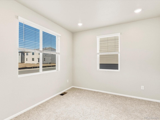 empty room with recessed lighting, baseboards, visible vents, and carpet