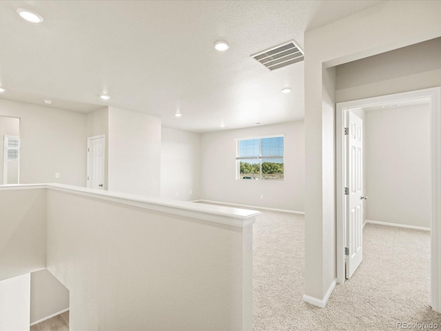 hallway with recessed lighting, carpet, visible vents, and baseboards