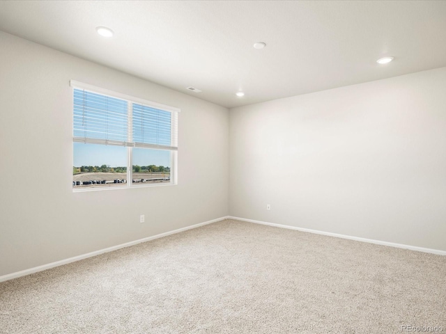 spare room featuring recessed lighting, carpet, visible vents, and baseboards