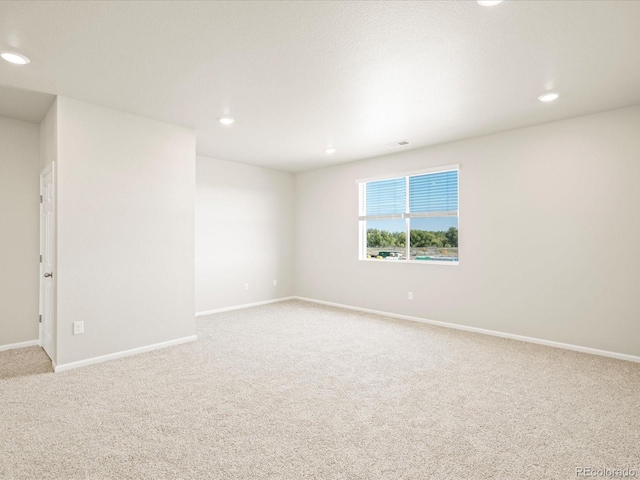 carpeted empty room featuring visible vents, baseboards, and recessed lighting
