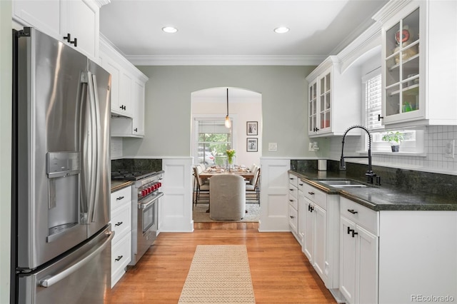 1767 S Sherman St, Denver, CO 80210 - kitchen with appliances with stainless steel finishes, a sink, arched walkways, dark countertops, and crown molding