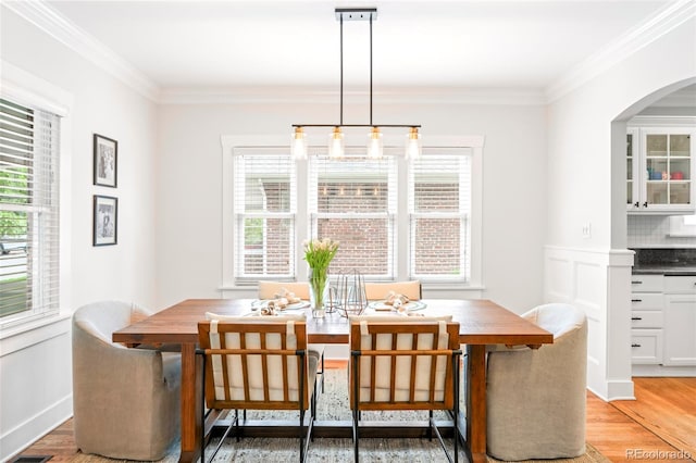 1767 S Sherman St, Denver, CO 80210 - dining area featuring light wood finished floors, healthy amount of natural light, arched walkways, and ornamental molding