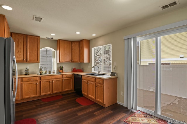 kitchen featuring stainless steel fridge with ice dispenser, plenty of natural light, sink, and black dishwasher