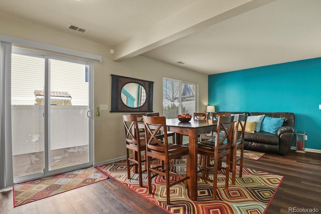 dining room with wood-type flooring and beamed ceiling