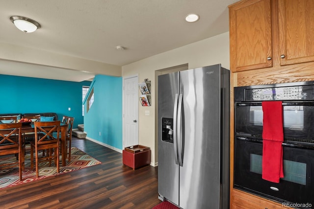 kitchen featuring stainless steel fridge with ice dispenser, dark wood-type flooring, and black double oven