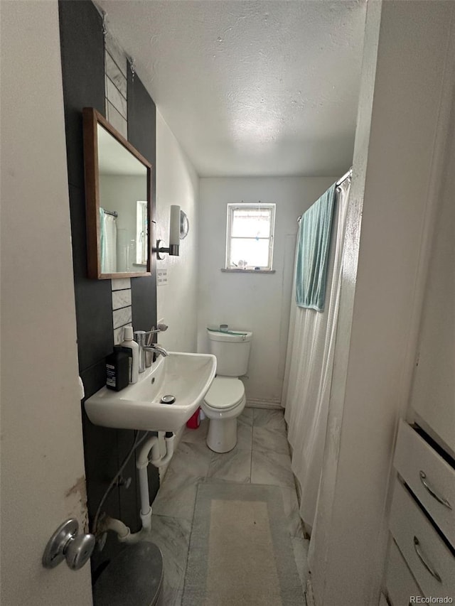1265 Yates St, Denver, CO 80204 - full bathroom featuring marble finish floors, a textured ceiling, and a shower with shower curtain