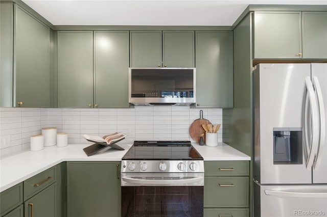 kitchen featuring backsplash, green cabinets, and stainless steel appliances