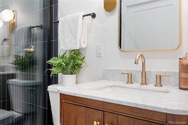 bathroom with toilet, vanity, and an enclosed shower