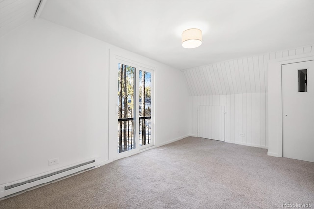 carpeted empty room with baseboard heating and lofted ceiling