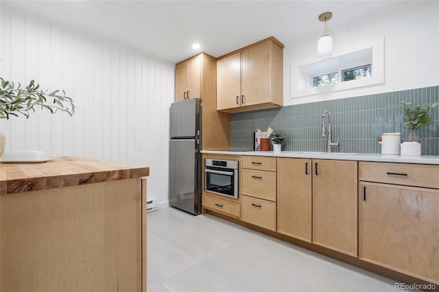 kitchen featuring decorative light fixtures, wooden counters, sink, stainless steel appliances, and light brown cabinetry